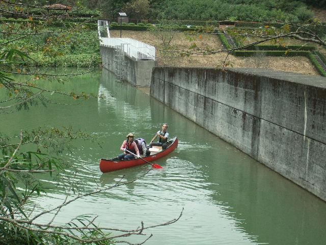 ダム湖に浮かぶカヌー。３名が乗船して作業を行っている。